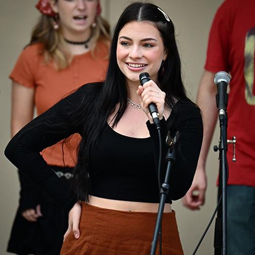 Woman with dark hair speaking into microphone